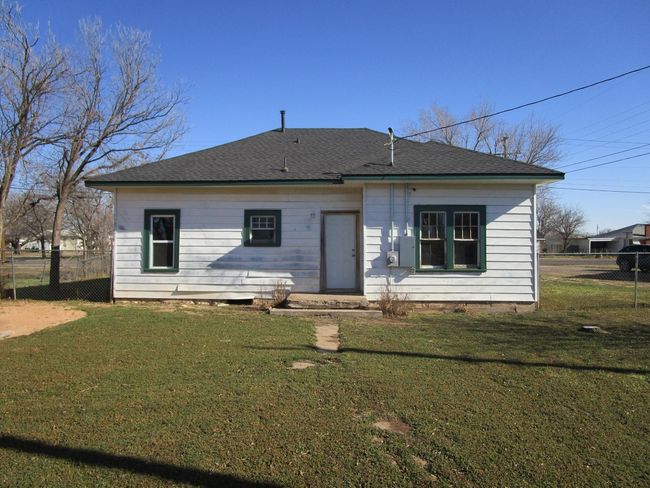 Rear view of house with a lawn, roof with shingles, and fence | Image 8