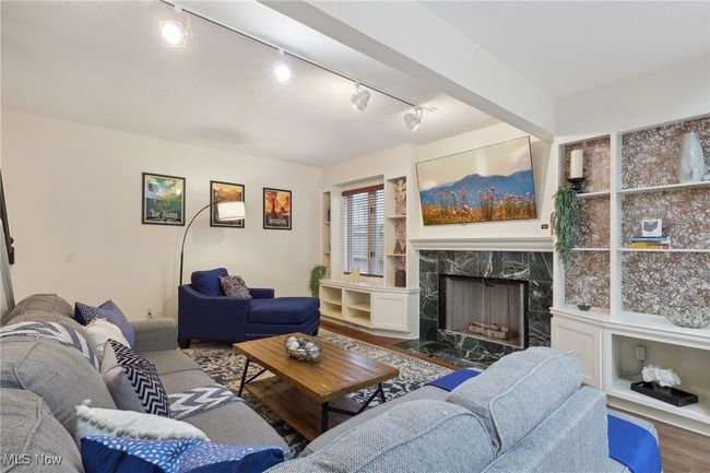 Living area with rail lighting, wood finished floors, and a high end fireplace | Image 10
