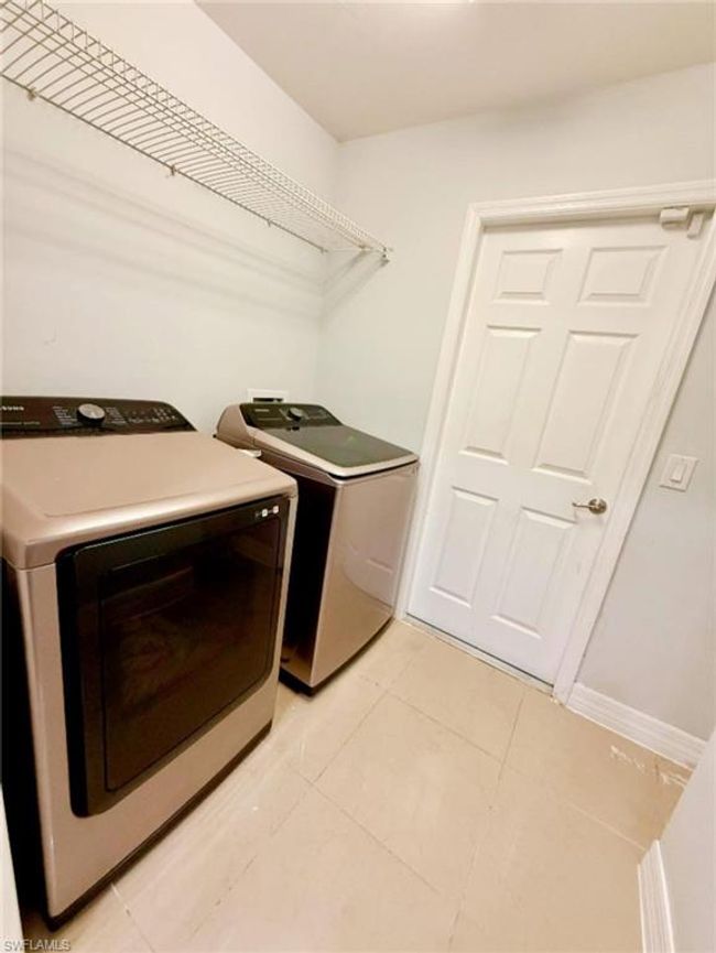 Washroom with light tile patterned floors, separate washer and dryer, and laundry area | Image 26