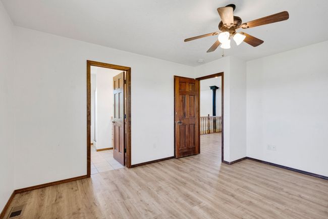 Spare room with light wood-style floors, baseboards, and ceiling fan | Image 34
