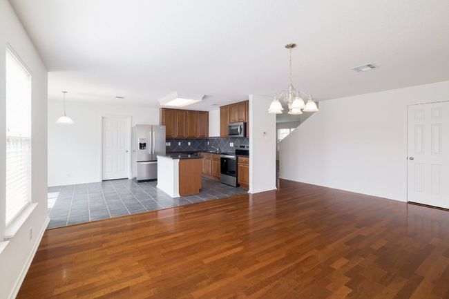 Kitchen featuring an inviting chandelier, open floor plan, visible vents, and stainless steel appliances | Image 10