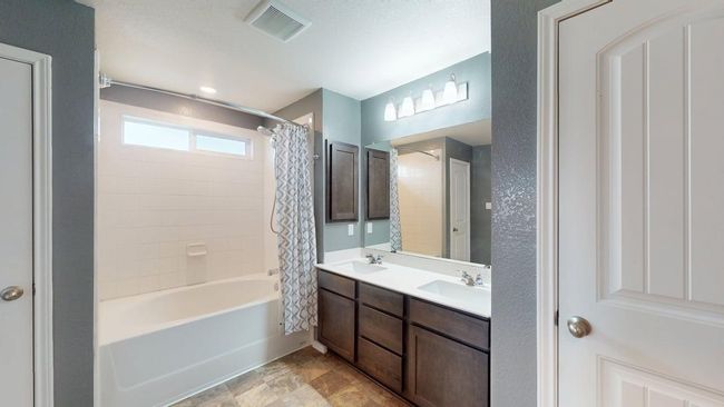 Full bath featuring double vanity, visible vents, a sink, and shower / bath combo | Image 27