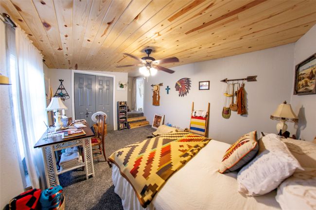 Carpeted bedroom featuring ceiling fan, a closet, and wooden ceiling | Image 19