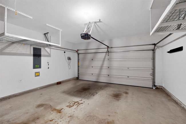 Garage featuring baseboards and a garage door opener | Image 34