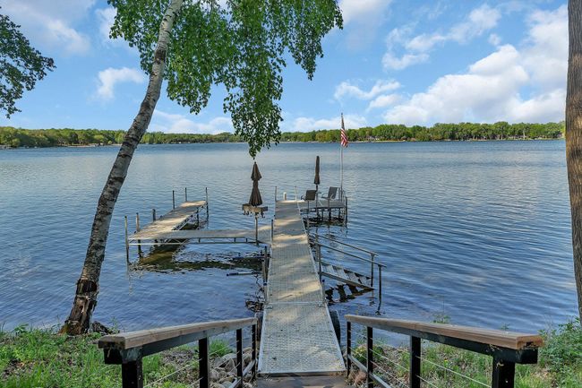 Spacious dock featuring ample seating, shaded by stylish umbrellas, offering a perfect spot to relax and enjoy the water. | Image 15