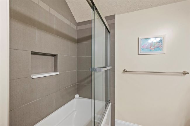 This natural linen style tile is sure to please in this guest shower. | Image 35