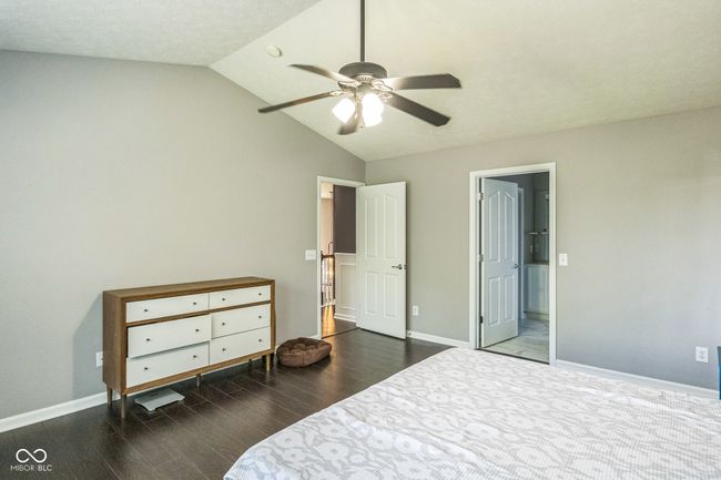 bedroom with wood finished floors, lofted ceiling, and a ceiling fan | Image 25