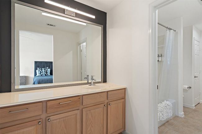 Ensuite bathroom featuring ensuite bathroom, visible vents, a shower with shower curtain, tile patterned floors, and vanity | Image 22