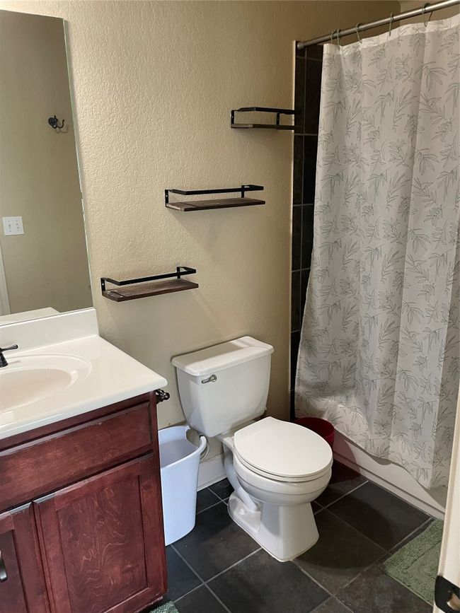 Full bathroom featuring vanity, tile patterned floors, toilet, and shower / tub combo | Image 22