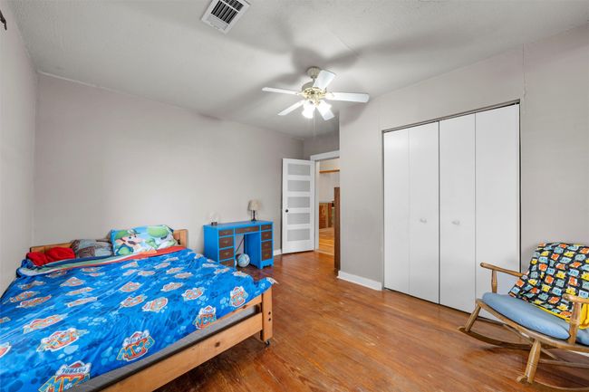 Bedroom with baseboards, visible vents, a ceiling fan, a closet, and wood finished floors | Image 13