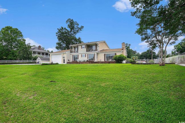 View of front facade featuring a chimney and an attached garage | Image 35