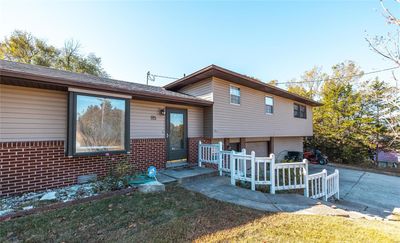 Tri-level home with a front yard and a garage | Image 1