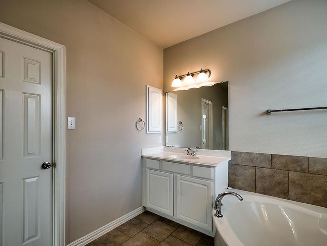 Bathroom featuring a garden tub, vanity, tile patterned floors, and baseboards | Image 32