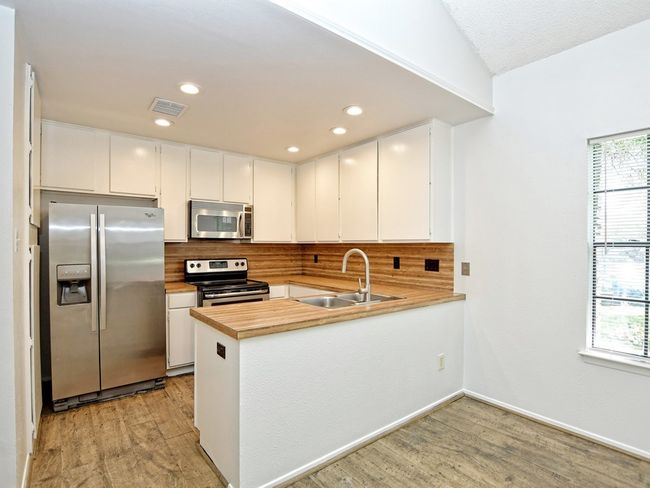 Kitchen with tasteful backsplash, visible vents, stainless steel appliances, and a sink | Image 7