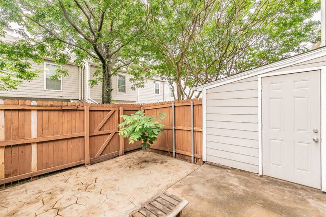 Fenced backyard with a patio area, an outbuilding, and a gate | Image 29