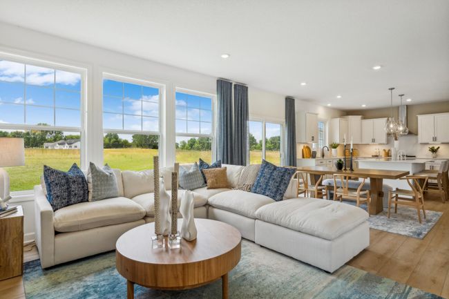Photo is of the actual model. The spacious great room seamlessly connects to the kitchen area, perfect for entertaining. It also features many large windows providing warm natural light. | Image 6