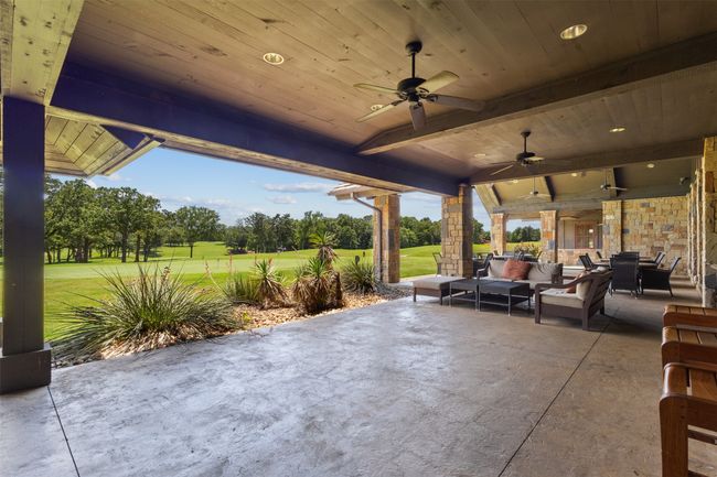 View of patio / terrace featuring outdoor lounge area, ceiling fan, golf course view, and view of scattered trees | Image 12