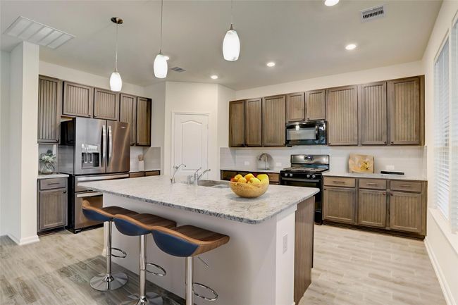 The kitchen is spacious, with plenty of cabinet and counter space for all your needs, plus room for bar stools. | Image 11