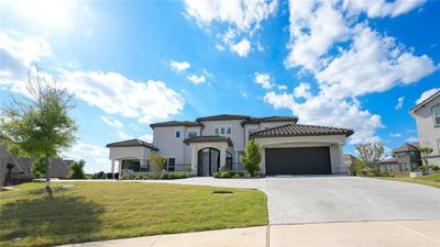 Mediterranean / spanish house featuring a front lawn and a garage | Image 1