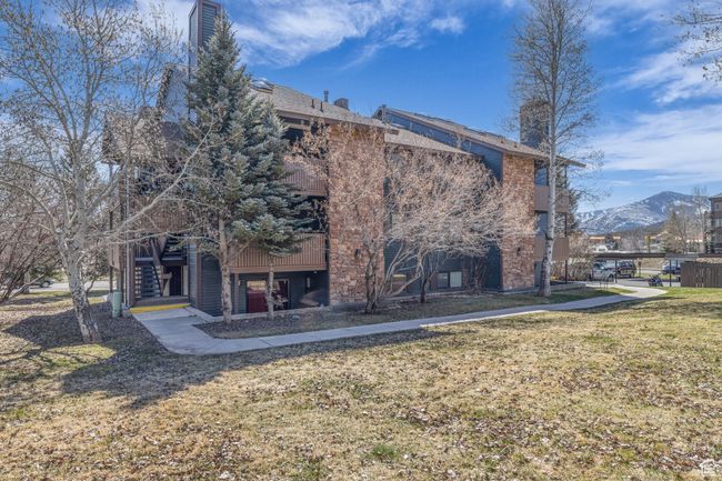 Rear view of house featuring a yard, stairway, a chimney, and a mountain view | Image 20