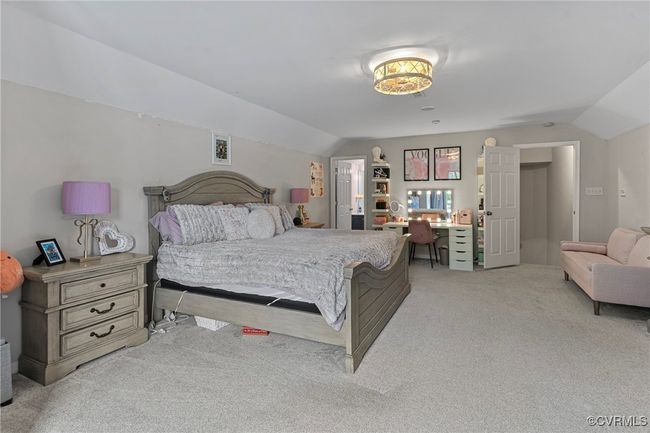 Bedroom with light colored carpet and lofted ceiling | Image 35