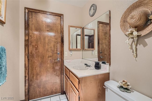 Bathroom with toilet, tile patterned flooring, and vanity | Image 16