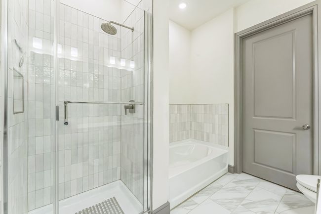 Bathroom featuring marble look tiles, a bath, a shower stall, and recessed lighting | Image 21