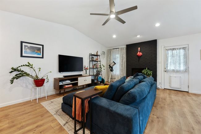 Living area featuring vaulted ceiling, baseboards, light wood-style floors, and ceiling fan | Image 7