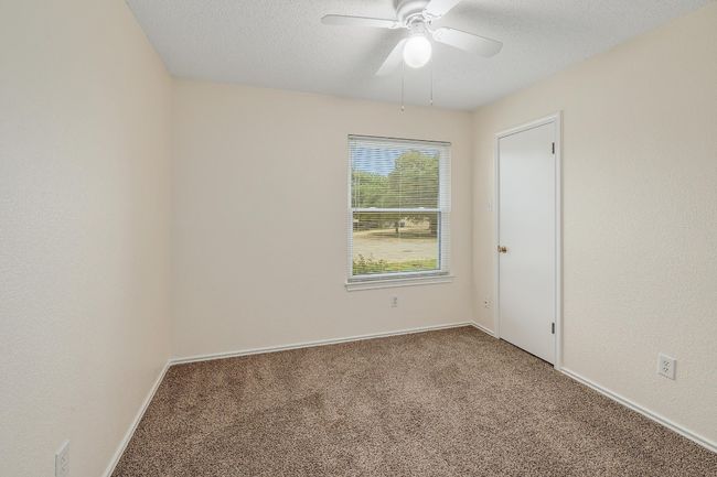 Carpeted empty room with a ceiling fan, baseboards, and a textured ceiling | Image 19