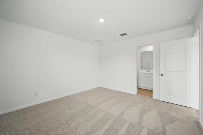Unfurnished bedroom featuring light colored carpet, ensuite bathroom, and recessed lighting | Image 13