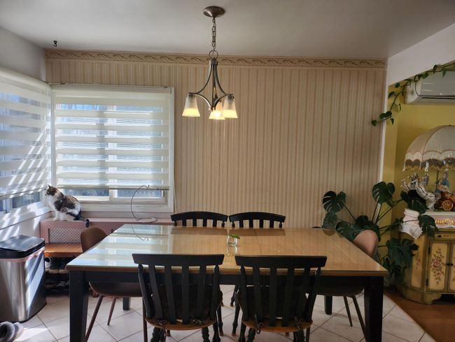 Dining room featuring light tile patterned floors, a notable chandelier, and a wall mounted air conditioner | Image 4