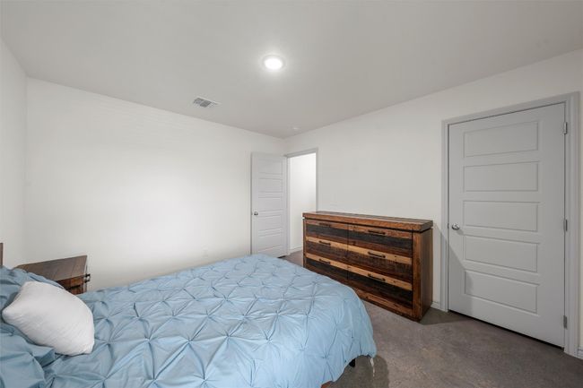 Bedroom featuring carpet flooring and visible vents | Image 21