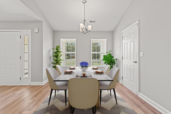 Dining room with light wood finished floors and a chandelier | Image 5