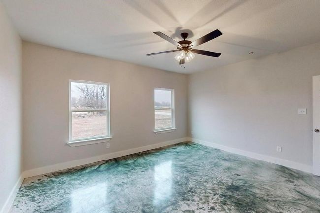 Spare room with concrete floors, baseboards, and a ceiling fan | Image 21