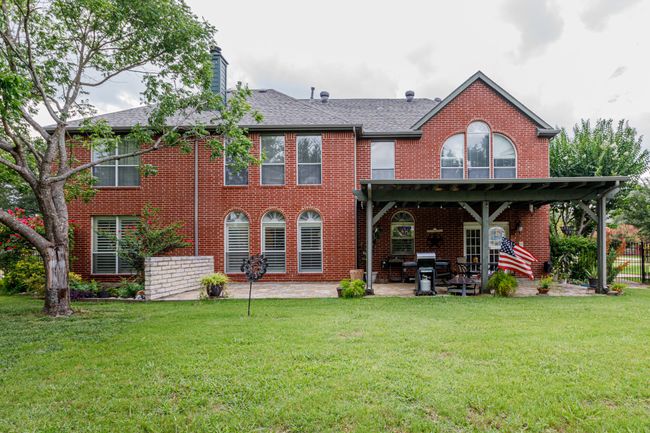 Rear view of house with a covered patio area, extended stamped concrete space. | Image 35