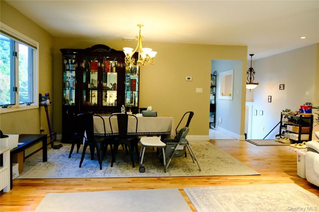 Dining area with light wood finished floors and a chandelier | Image 13