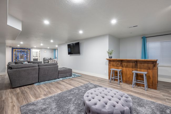 Living room with bar area and light wood-type flooring | Image 31