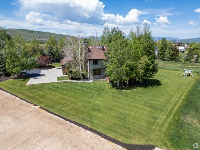 View of front of property with a chimney, a mountain view, and a front lawn | Image 77