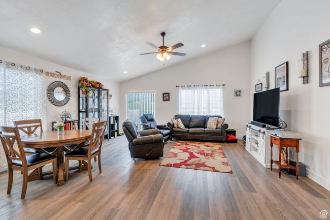 Living area with lofted ceiling, a ceiling fan, light wood-style flooring, and recessed lighting | Image 4