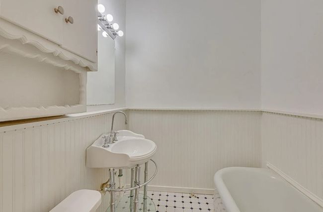 Bathroom featuring wainscoting and a freestanding tub | Image 9