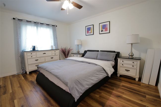 Bedroom featuring crown molding, dark wood finished floors, and ceiling fan | Image 20