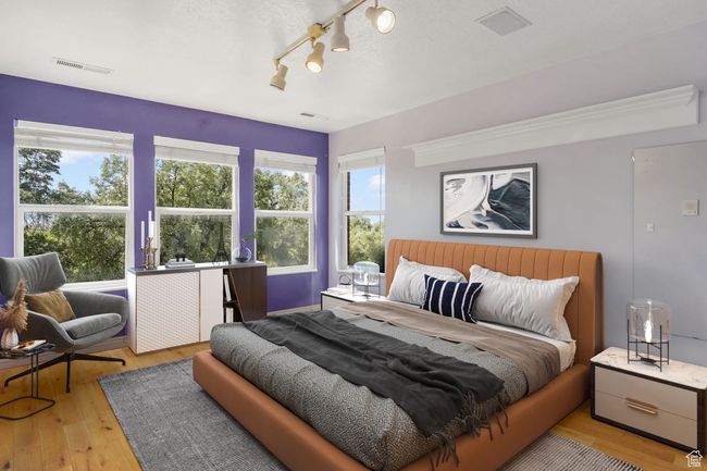 Bedroom featuring visible vents, light wood-type flooring, and rail lighting | Image 14