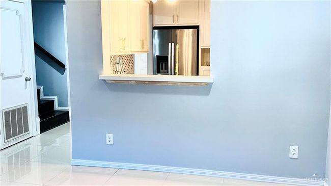 Detailed view of stainless steel fridge with ice dispenser and light countertops | Image 11