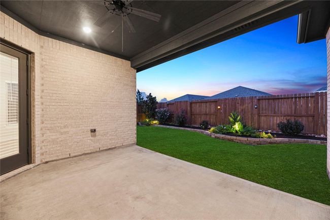 The spacious covered patio is ready for outdoor living year-round, with a ceiling fan for warm days and plenty of room for seating, dining, or grilling. It’s the perfect spot to relax, unwind, and enjoy your backyard in comfort. | Image 35