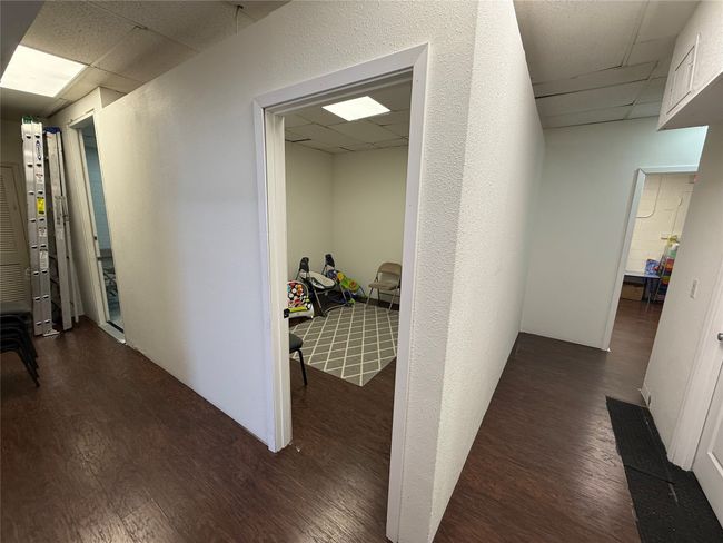 Hall with a drop ceiling and wood finished floors | Image 8