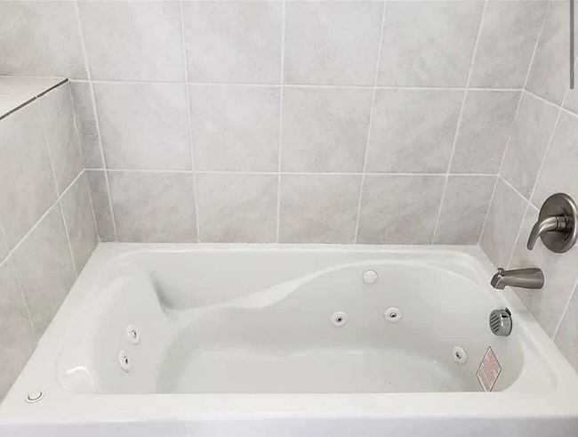 Bathroom featuring a tub with jets | Image 11