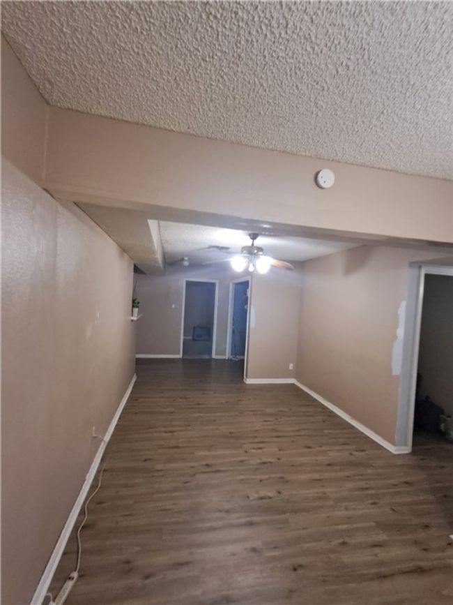 Finished below grade area featuring wood finished floors and a textured ceiling | Image 13