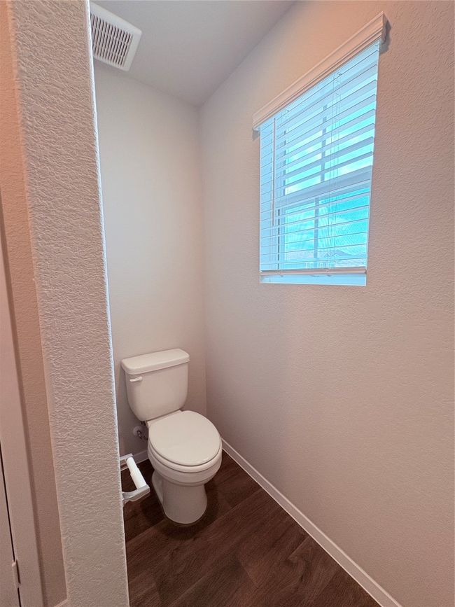 Bathroom with toilet, wood finished floors, visible vents, and baseboards | Image 31