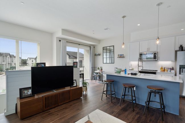 Kitchen featuring stainless steel microwave, refrigerator with ice dispenser, dark wood finished floors, and recessed lighting | Image 20