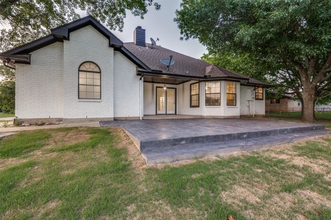 Back of house with a patio, a chimney, brick siding, french doors, and roof with shingles | Image 22